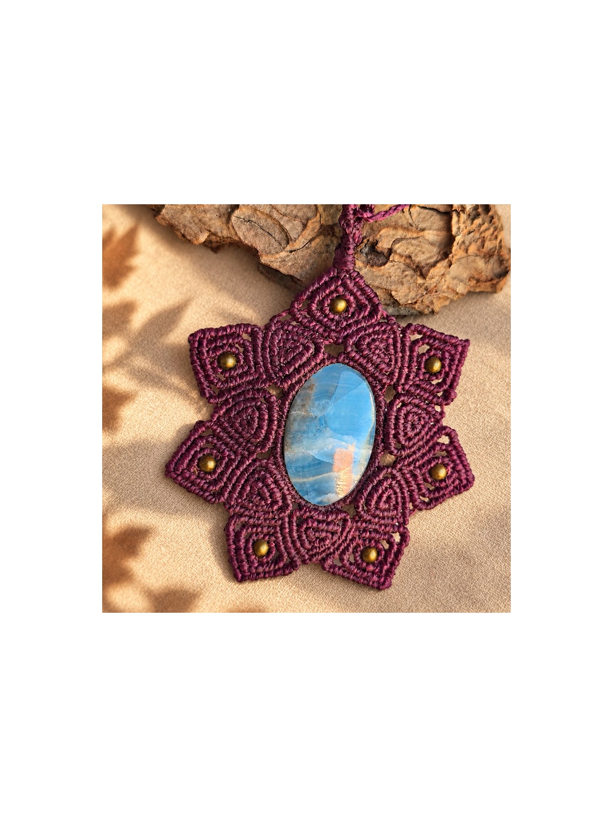 Detalle del mandala burdeos tejido alrededor del ónix cielo